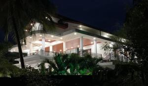 duży biały dom z oświetleniem w nocy w obiekcie Villa Exora Pasikudha w mieście Batticaloa