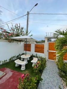 eine Terrasse mit zwei Bänken und einem Sonnenschirm in der Unterkunft Villa confortable para 5 pesonas in Pedernales