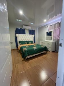 1 dormitorio con cama, tocador y espejo en Villa confortable para 5 pesonas, en Pedernales