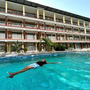 eine Person, die in einem Pool vor einem Hotel schwimmt in der Unterkunft Royal Villa Beach Resort in Havelock Island