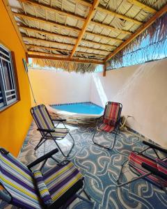 Habitación con 2 sillas y piscina en Villa confortable para 5 pesonas, en Pedernales