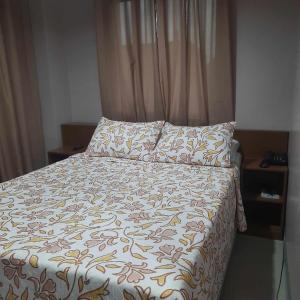 łóżko w sypialni z narzutą i poduszkami w obiekcie Lorraine Suites w mieście Borongan
