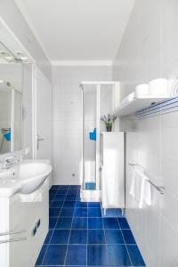 a bathroom with a white sink and a blue tile floor at LA MAR Apartment Spinea in Spinea