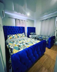 a bedroom with a blue bed and a blue couch at Villa confortable para 5 pesonas in Pedernales