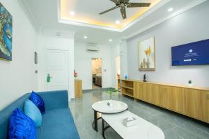 een woonkamer met een blauwe bank en een tafel bij Cambana Poipet Hotel in Krong Poi Pet