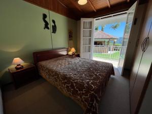 a bedroom with a bed and a large window at Recanto Habacuque in Campos do Jordão
