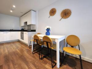 una cucina e una sala da pranzo con tavolo e sedie di RIVERSIDE OASIS station-parking-riverboat a Woolwich