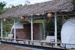 Ban Rak Thai的住宿－Dome tents Hedreung Rakthai camping，一个带椅子和茅草屋顶的凉亭