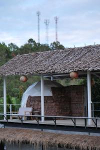 um pavilhão com uma mesa e uma cadeira sobre a água em Dome tents Hedreung Rakthai camping em Ban Rak Thai