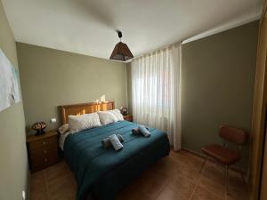 a bedroom with a blue bed and a chair at APARTAMENTOS MATEO in Rillo de Gallo