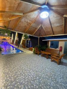 un bâtiment avec une piscine, des bancs et un plafond dans l'établissement Villa completa confotable para 9 personas, à Pedernales