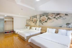 2 Betten in einem Zimmer mit Blumen an der Wand in der Unterkunft Hotel Pansy in Da Lat