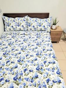 1 cama con sábanas azules y blancas y flores azules en New, Modern 2 Bedroom Condo, Free Hi-Speed Wifi, en Iloilo City