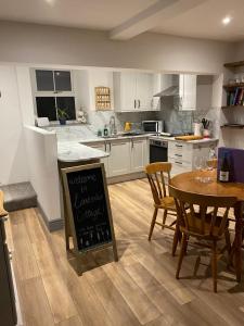 a kitchen with a table with a chalkboard in it at Lavender Cottage, Masham, Historic Listed, 2 bedrooms in Masham