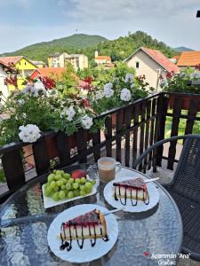 Gračac的住宿－ANA，阳台上的一张桌子上放着三盘食物