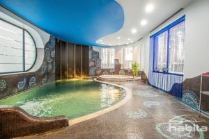 a swimming pool in a room with a blue ceiling at Cozy house with sauna, pool and private garden in Riga