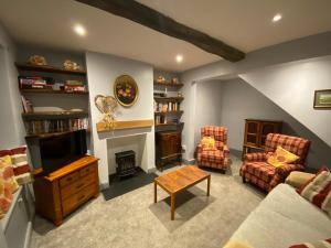 a living room with two chairs and a fireplace at Lavender Cottage, Masham, Historic Listed, 2 bedrooms in Masham