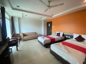 um quarto de hotel com duas camas e um sofá em Hotel Sunview Guwahati em Guwahati