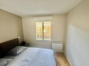 een slaapkamer met een bed en een raam bij Le Sept avec parking, transfert in Vaires-sur-Marne