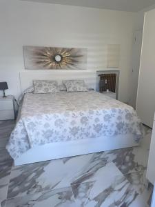 a bedroom with a large bed with a flower picture on the wall at Andrea's holydays in Roquebrune-Cap-Martin