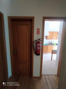 Ein Feuerlöscher hängt an der Wand neben einer Tür. in der Unterkunft Room II MCR Barreiro - Lisboa in Lavradio