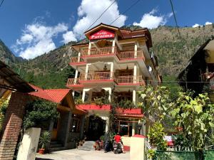 a large building with people standing in front of it at Purnima Guest House, Old Kasol in Kasol