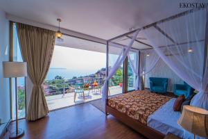1 dormitorio con cama con dosel y balcón en Ekostay Gold- Salt Water Villa I Sea View I 200 meters from Beach en Candolim