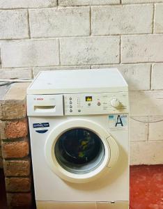 eine Waschmaschine neben einer Ziegelwand in der Unterkunft Arusha Jua home in Arusha