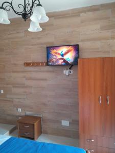 1 dormitorio con pared y TV. en ARIS, en Symi