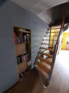 escalera en una habitación con estantería en Maison Cosy, cœur de village en École