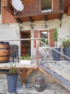 patio con macetas y balcón en Maison Cosy, cœur de village en École