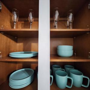 a cupboard filled with blue dishes and glasses at Cozy Place in Old Seminole Heights + 2 Queen + 1Sofa Bed in Tampa