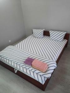 a bed with two pillows and two towels on it at Мини-гостиница in Kamianets-Podilskyi