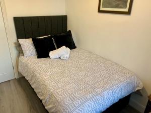 a bedroom with a bed with a black and white comforter at Blossom Holiday Lets - 3 Bed Bensham Apartment in Gateshead