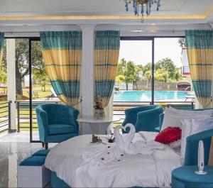 a bedroom with a bed and chairs and a pool at The Lion Kingdom Sigiriya in Sigiriya
