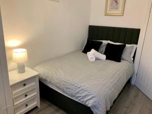 a bed with a green headboard and a night stand at Blossom Holiday Lets - 3 Bed Bensham Apartment in Gateshead