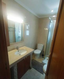 ein Badezimmer mit einem Waschbecken, einem WC und einem Spiegel in der Unterkunft Room II MCR Barreiro - Lisboa in Lavradio
