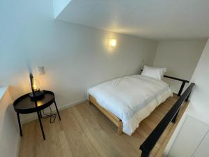 Dormitorio pequeño con cama y mesa en 【ペット可】Niseko STREAM Villas, en Rankoshi