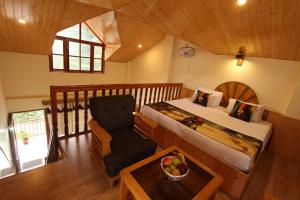 a bedroom with a bed and a chair in a room at Purnima Guest House, Old Kasol in Kasol