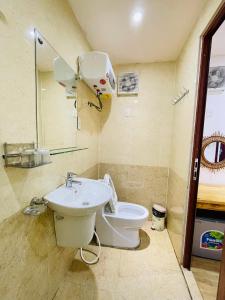 a bathroom with a toilet and a sink at Homestay Gió Mộc in Mộc Châu