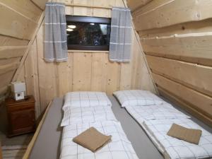 2 Betten in einer Hütte mit Fenster in der Unterkunft Chata Zuzka pod Babou horou in Oravská Polhora