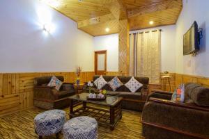 a living room with couches and a coffee table at Hotel Hadimba Manali By YB Hotels in Manāli