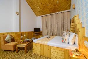 Hotel Hadimba Manali By YB Hotels في مانالي: غرفة نوم بسرير واريكة وطاولة