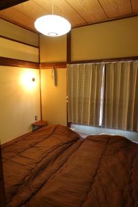 會津若松的住宿－末廣宿(女性専用)- suehirojyuku for woman- by mooi，一间卧室设有一张大床和一个窗户。