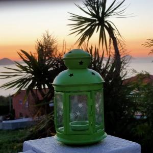 una linterna verde sentada en una mesa con una puesta de sol en el fondo en Casa Zona Playa, en Vigo