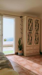 1 dormitorio con puerta y planta junto a una ventana en Casa Zona Playa, en Vigo