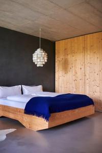 um quarto com uma cama grande e um cobertor azul em Alpenchalet Walchensee em Walchensee