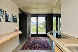 a kitchen with a large window and a rug at Alpenchalet Walchensee in Walchensee