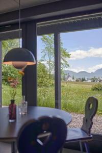 a table and chair in a room with a view of a field at Alpenchalet Walchensee in Walchensee