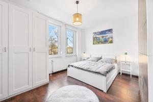 a white bedroom with a bed and two windows at 3-Zimmer-Wohnung in Leonberg in Leonberg